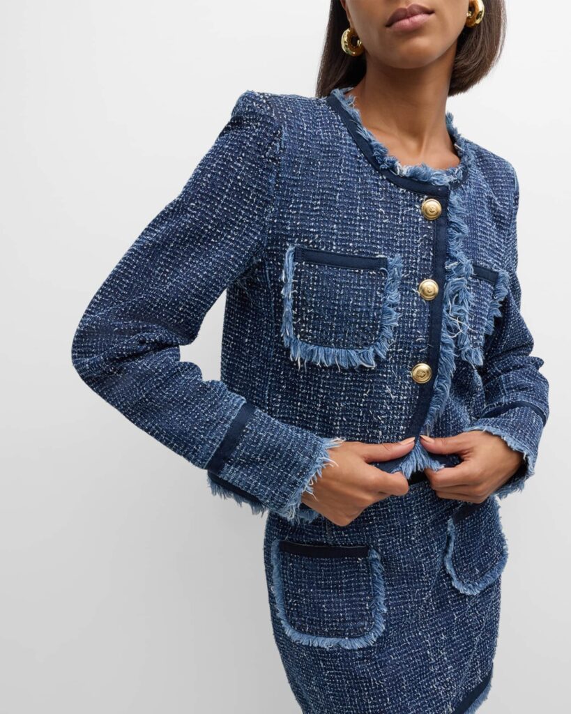 Close-up studio shot of a woman wearing an old money style blue denim tweed bouclé jacket with frayed edges and embossed gold buttons from The City Sophisticate.jpg. The outfit features matching denim tweed pocket details and chunky gold hoop earrings.